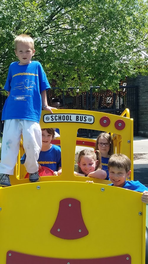Kids on yellow school bus playground