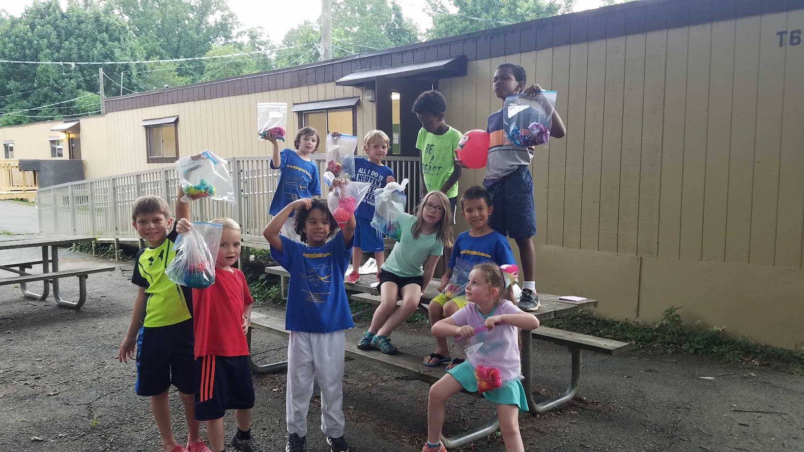 Kids holding tie-dye bags group photo